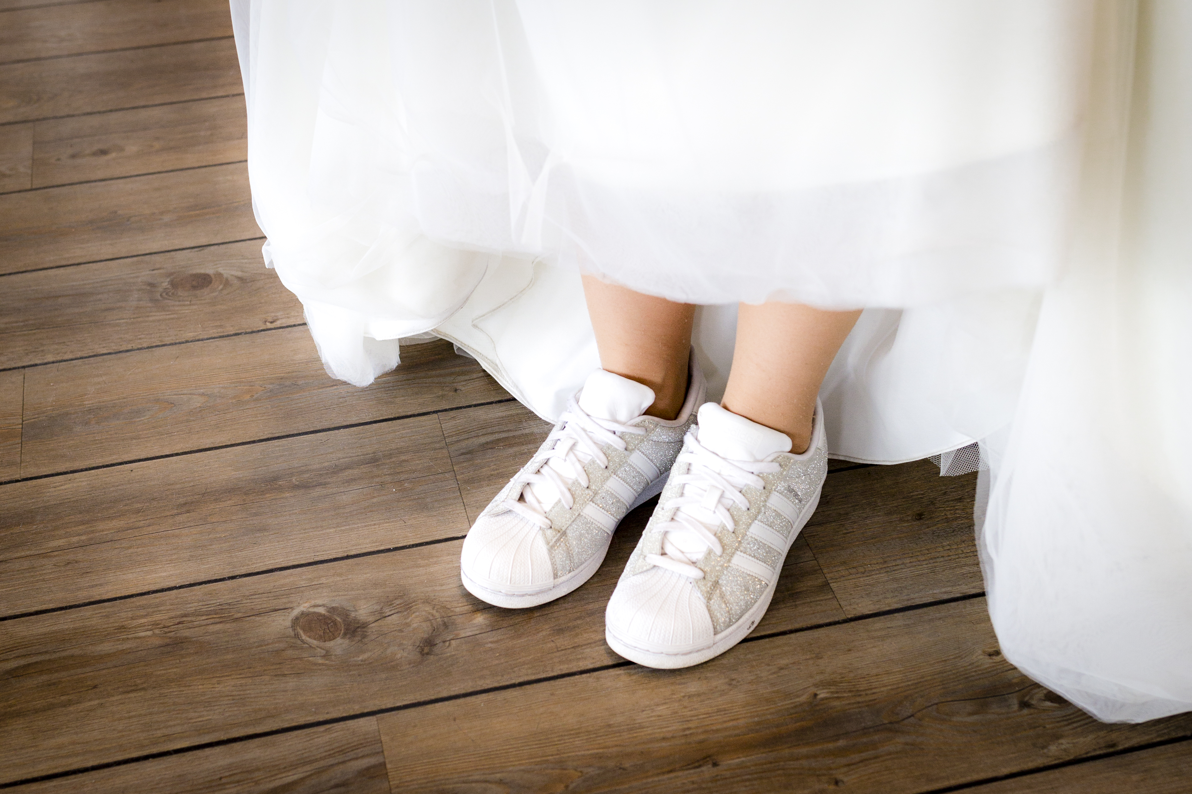 Braut in weißem Kleid und Turnschuhen